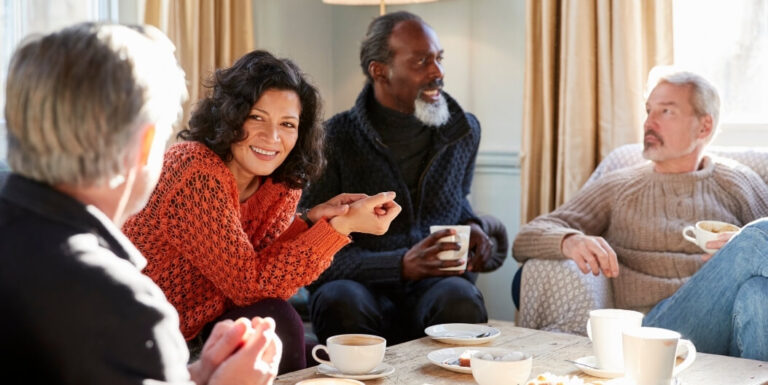 Small Group of Residents Enjoying Coffee and Conversation Indoors at an Assisted Living Facility