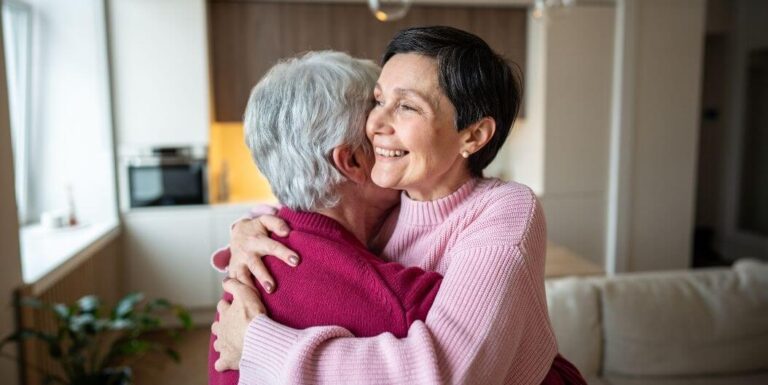 Adult Daughter Hugging Elderly Mother at Assisted Living Facility